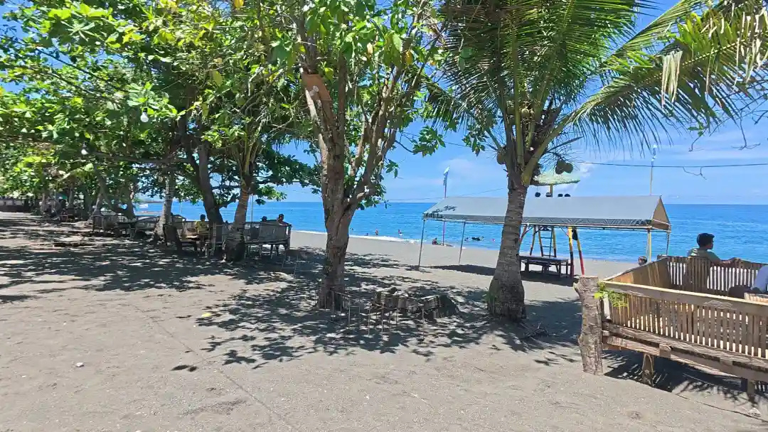 Bamboo bench seating and a small wooden gazebo under mature shade trees along the promenade at Sunrise Beach Resort Pili Pinamalayan Oriental Mindoro