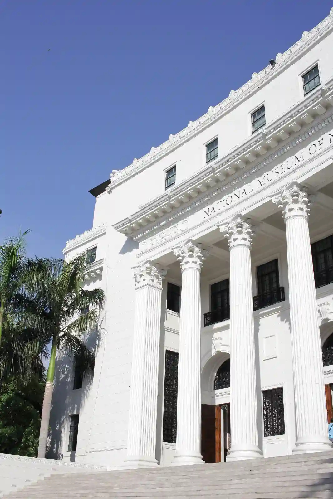 Close angle of National Museum of Natural History facade with Corinthian columns under blue sky in Manila