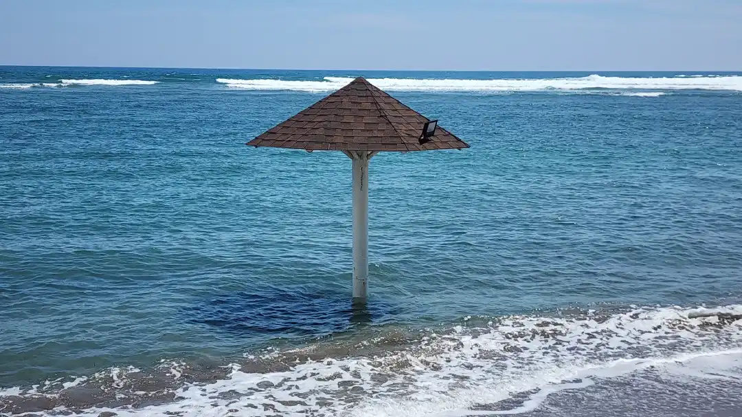 Wooden beach umbrella standing in the sea at high tide at Bataan White Corals in Morong Bataan