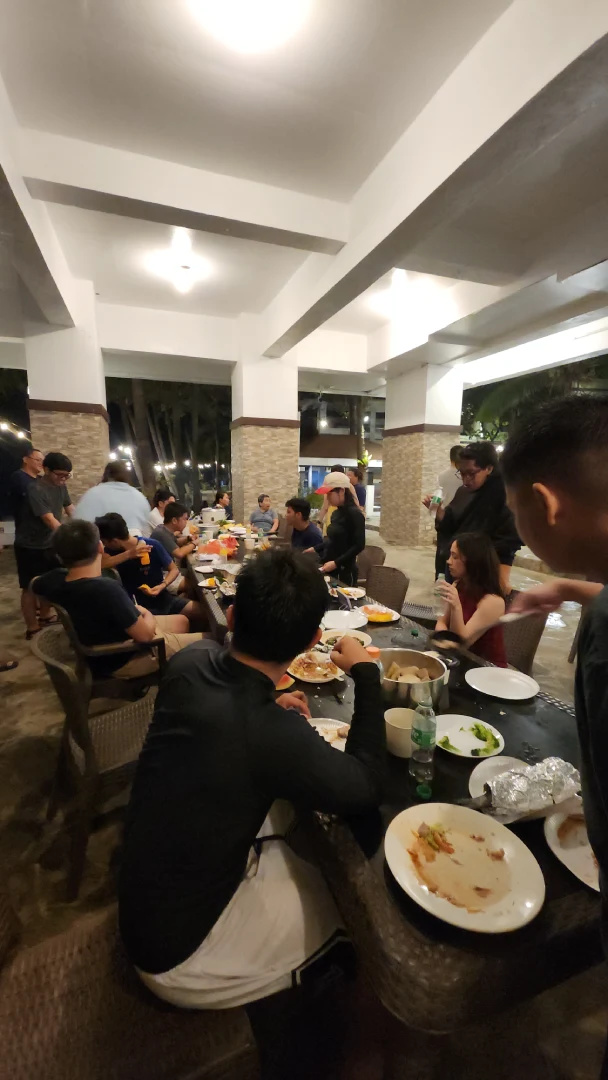Large group seated at a long table eating dinner on a covered patio at Bataan White Corals in Morong Bataan