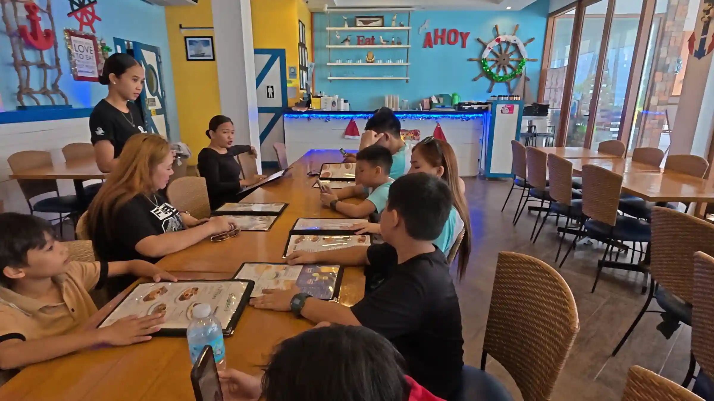 Family group reading menus at Giligans restaurant inside Moadto Strip in Panglao, Bohol