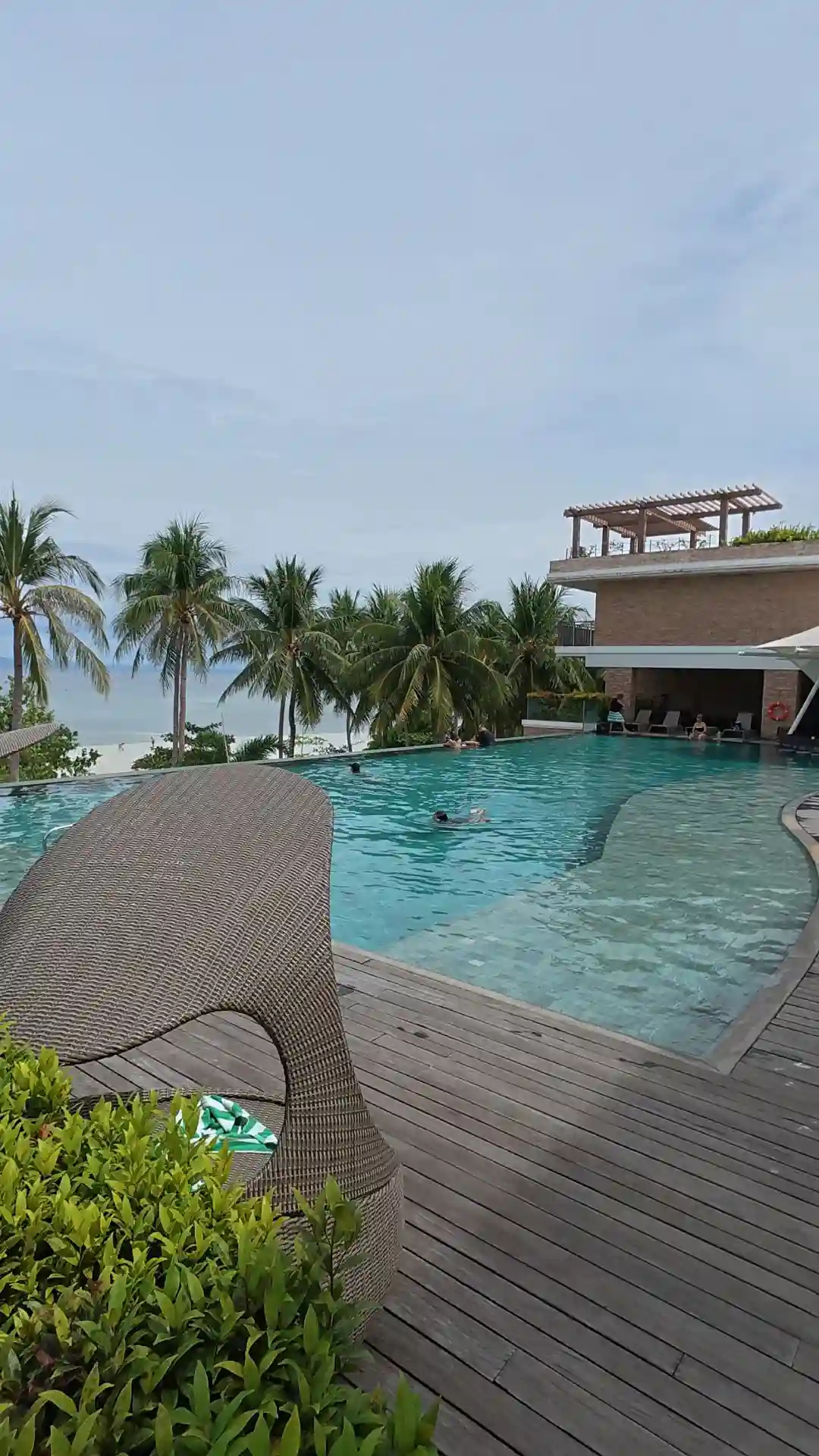 Infinity pool with coconut palms and the sea beyond at Modala Beach Resort next to Doljo, Panglao