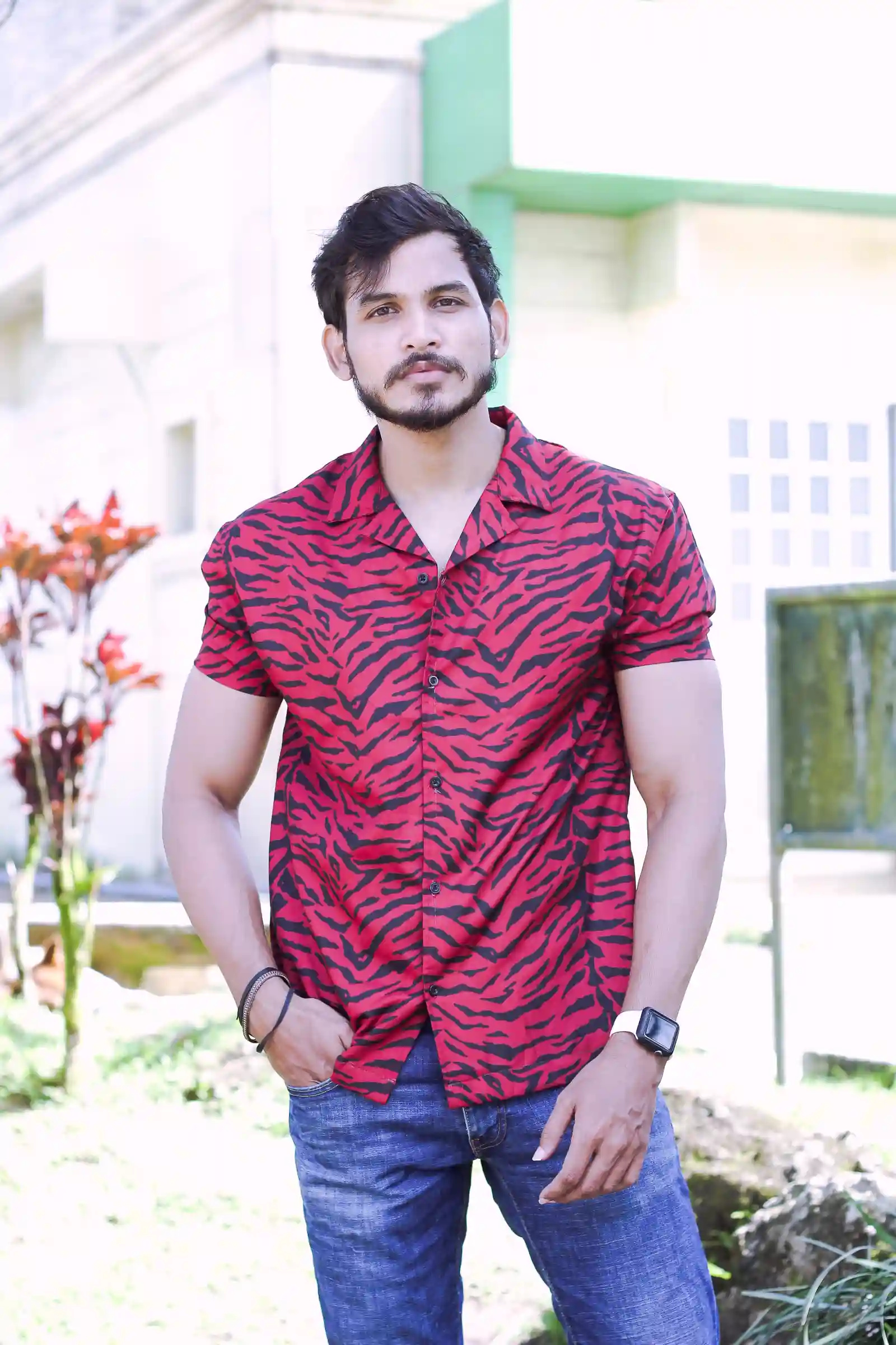 Kunwar standing near a pale building with green trim at Peoples Park in the Sky Tagaytay