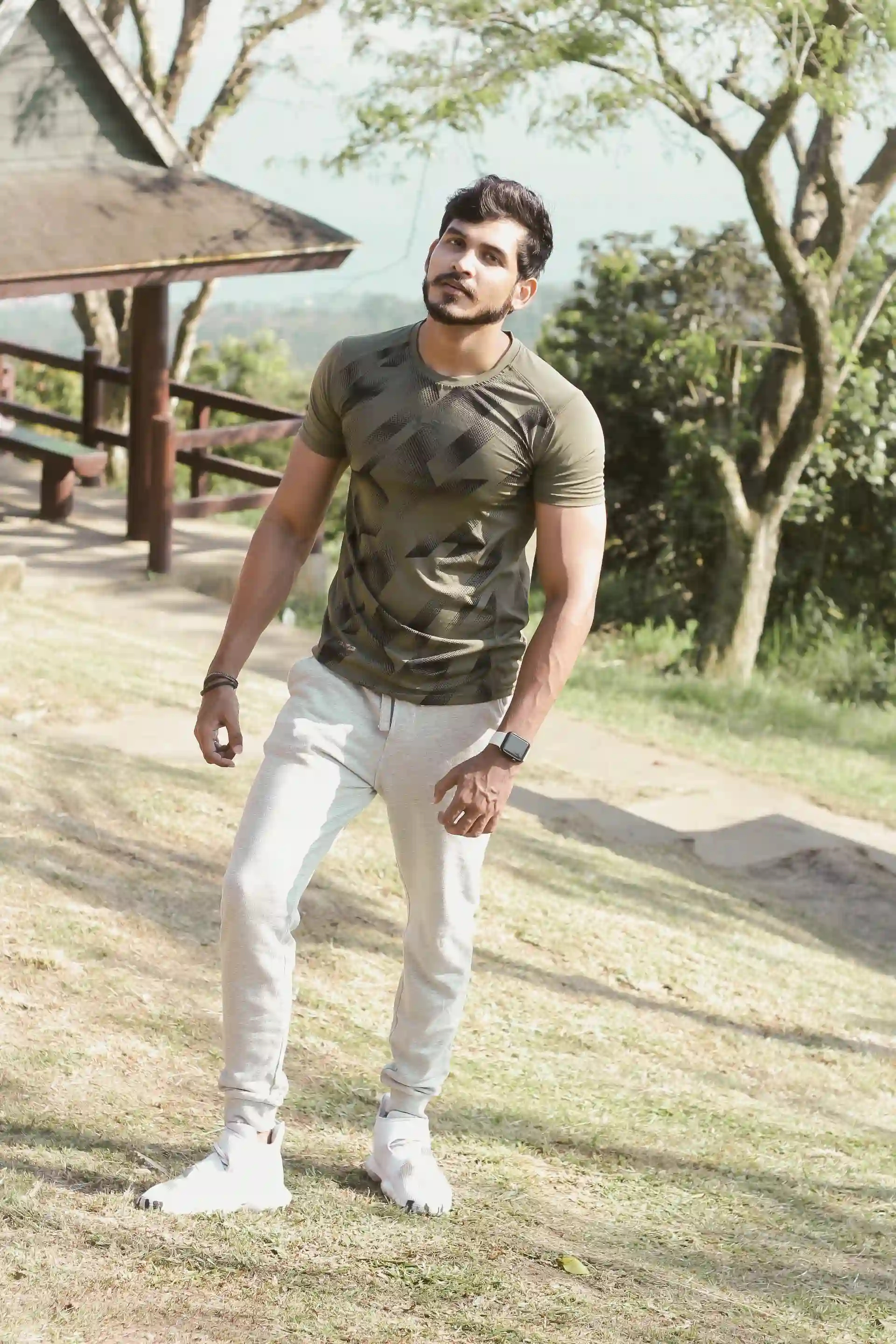 Kunwar standing on grass near a wooden pavilion at Picnic Grove in Tagaytay