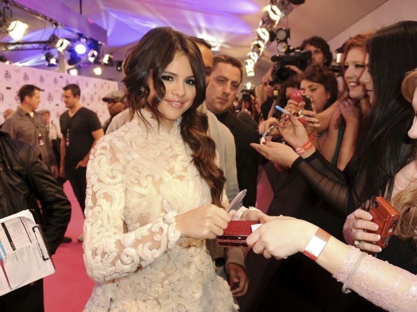 Selena Gomez smiling on the red carpet at an entertainment awards show