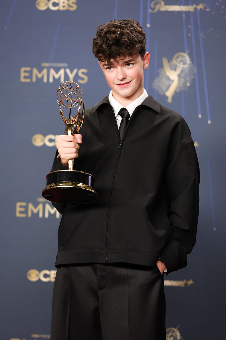 Owen Cooper holding his Primetime Emmy Award trophy on the red carpet