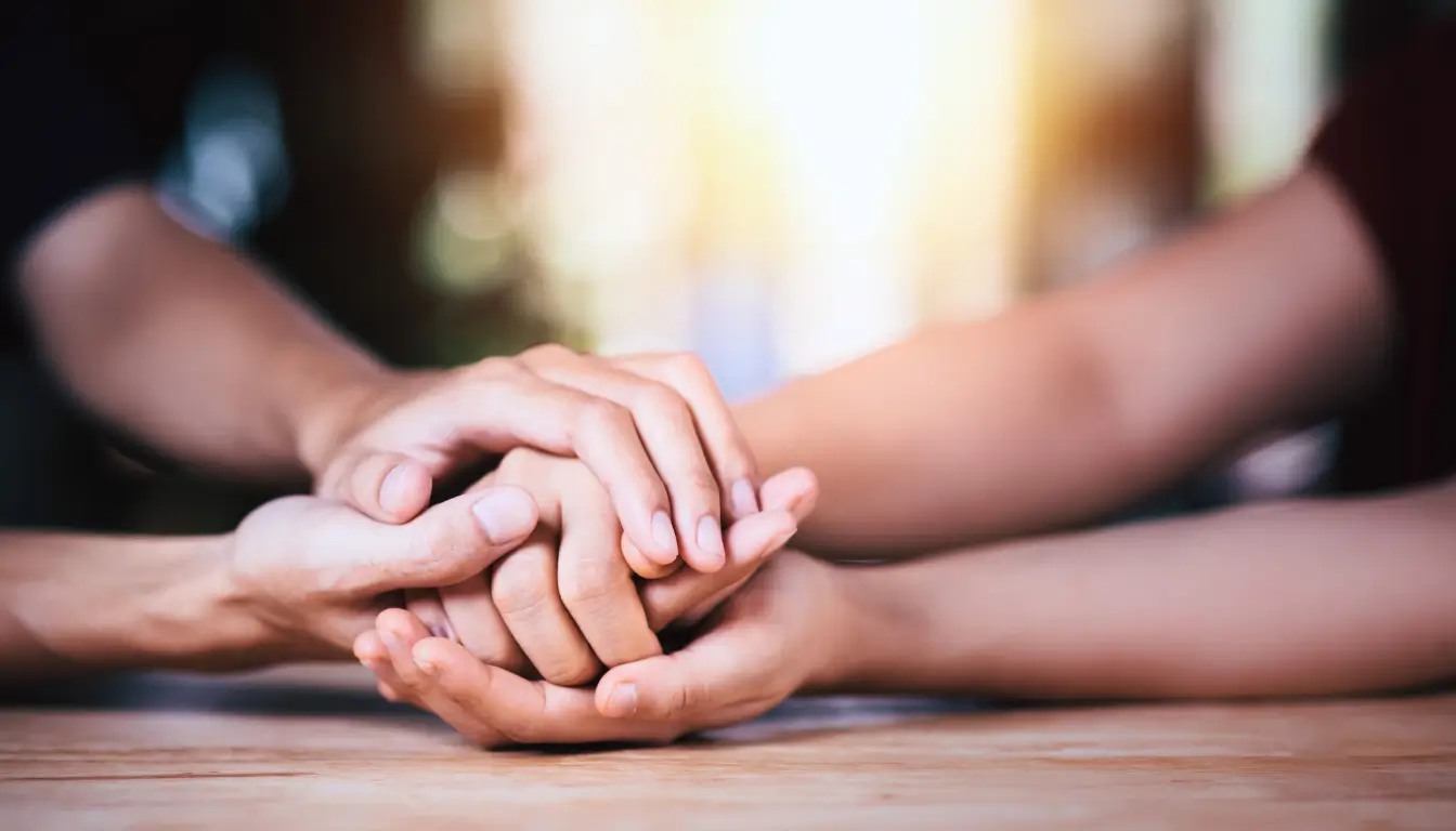 Holding hands symbolizes support among expats who are experiencing challenges like cognitive dissonance.