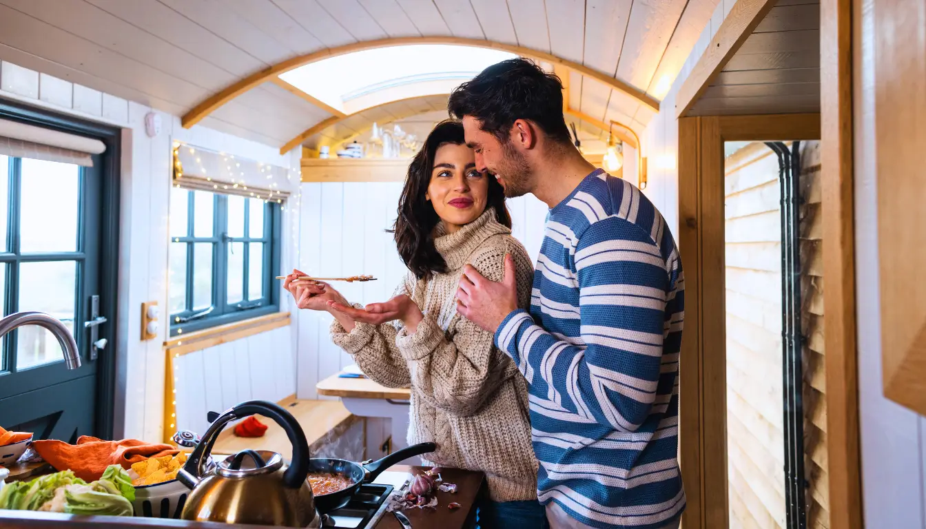 A couple cooking together, enjoying their dinner ritual, symbolizing how shared routines strengthen their bond after moving in together.