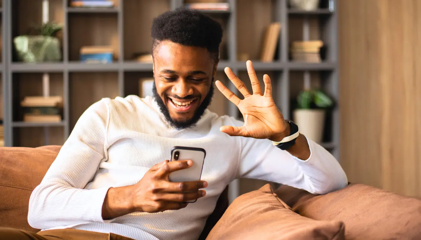 Smiling man on a video call, communicating and connecting with a partner in a long-distance relationship.