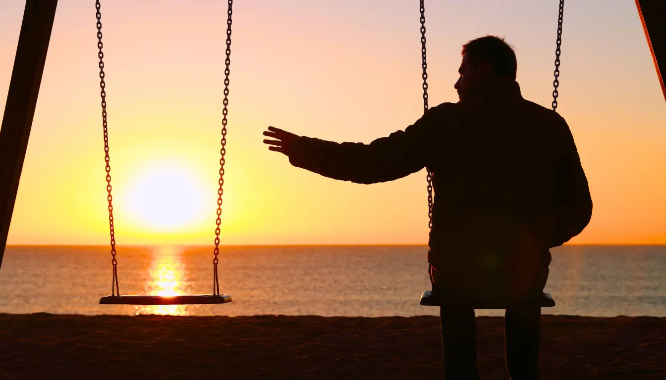 Silhouette of a person on a swing at sunset, symbolizing loneliness in a long-distance expat relationship.