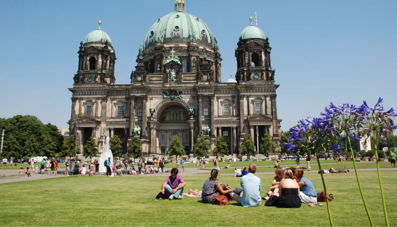 An image shows people socializing outdoors in Berlin, symbolizing expat support groups in Germany.