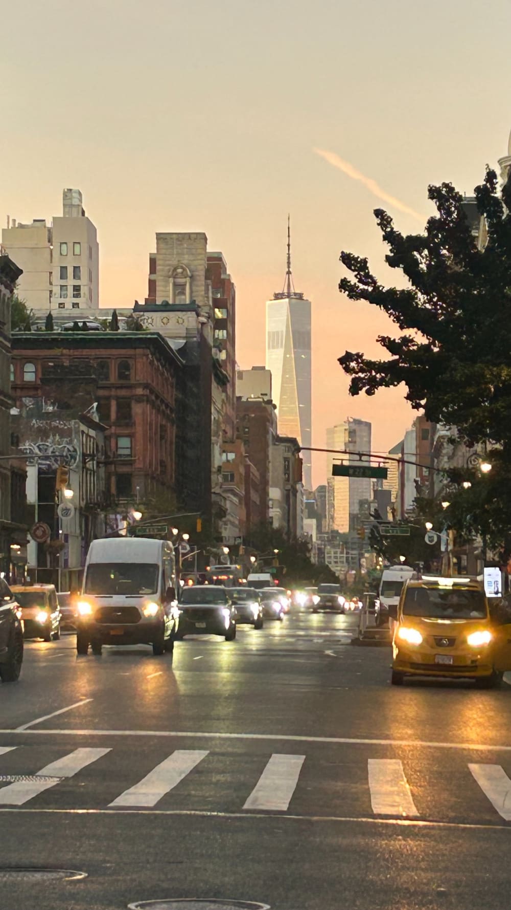 A street in New York City filled with cars during sunset. 