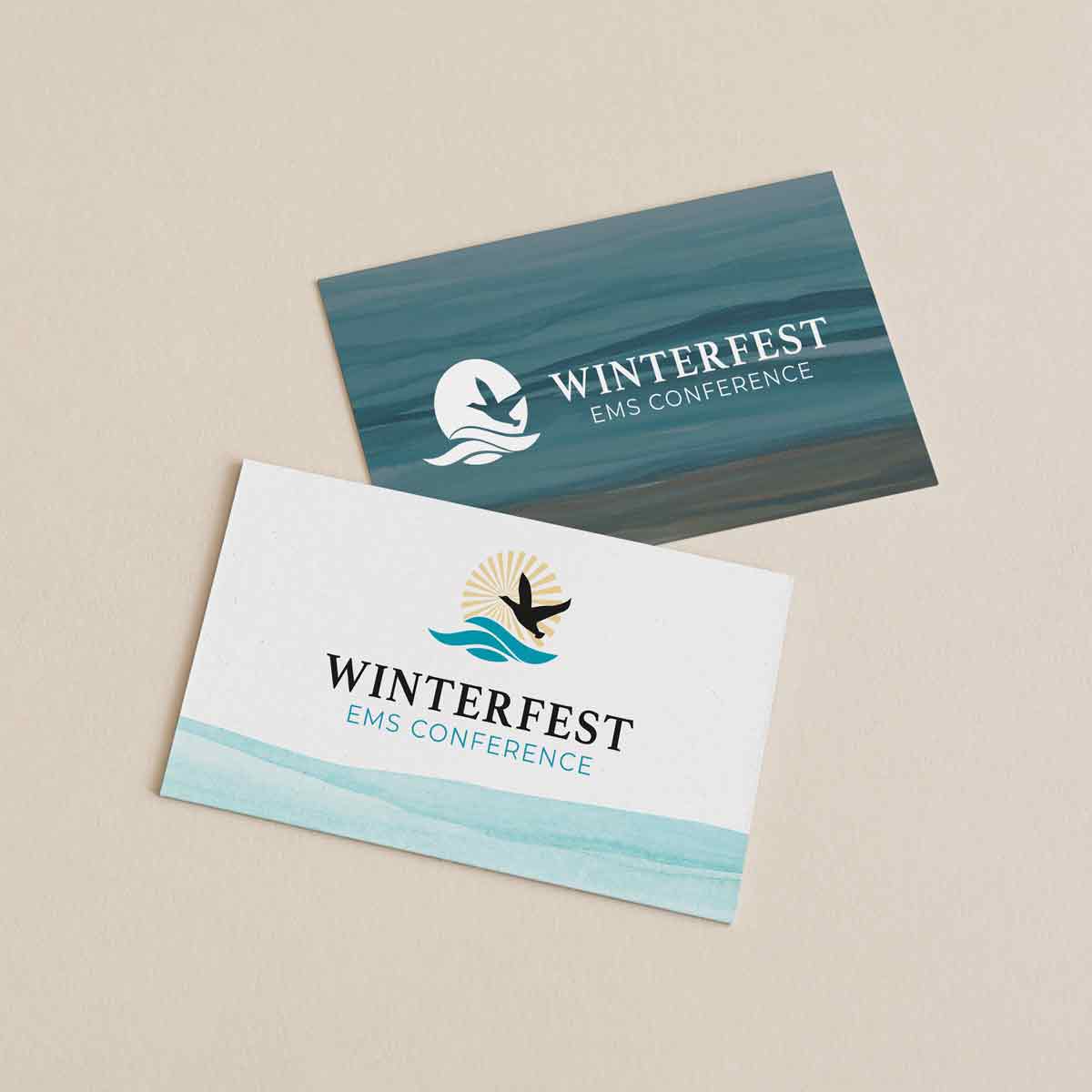 Two cards; the front card has the colored logo for Winterfest on it with watercolor waves underneath. The back card has the ocean painted with watercolors and a white Winterfest logo