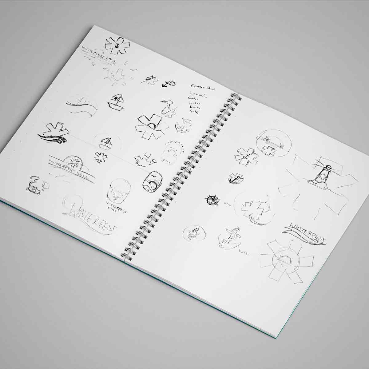 A open sketchbook with initial sketch designs for the Winterfest logo