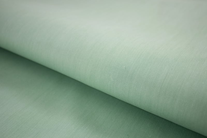 Fine weave detail of sage green smooth cotton shirt fabric