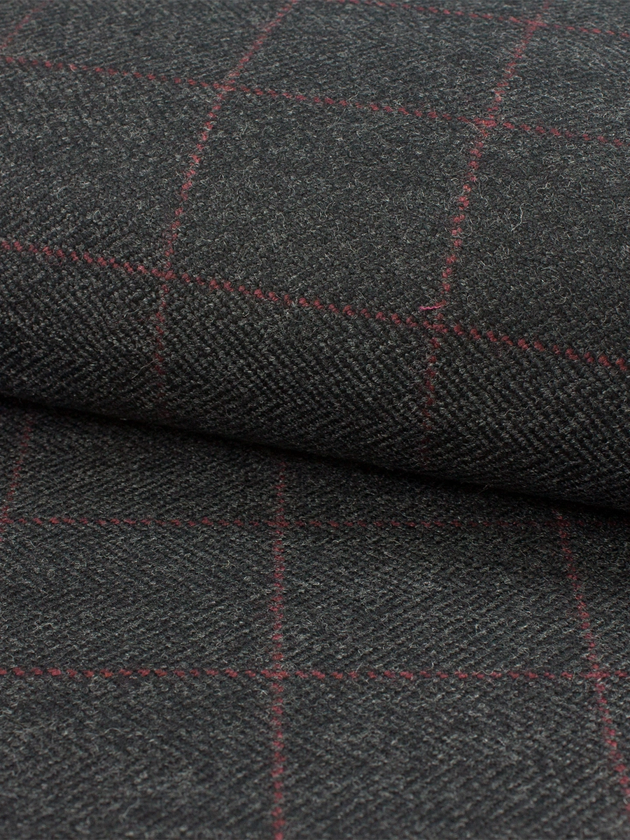 Close-up of a premium charcoal wool tweed fabric featuring a traditional herringbone weave and subtle red windowpane overcheck pattern with a soft matte winter texture