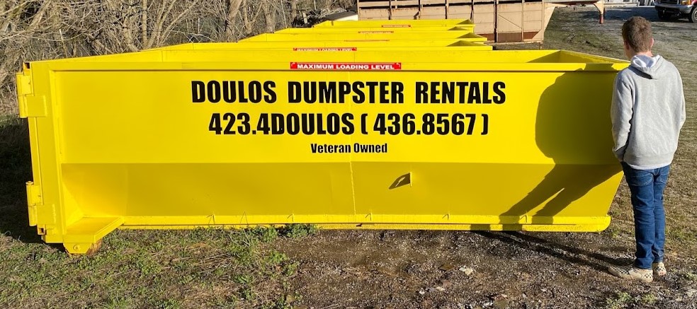 Yellow Doulos roll-off dumpster delivered to a Bristol TN job site