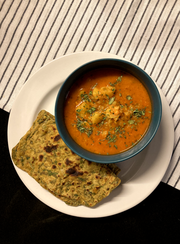 A low-effort, high-comfort tomato gravy with soft, crumbly aloo, steeped in turmeric, coriander, and kasoori methi