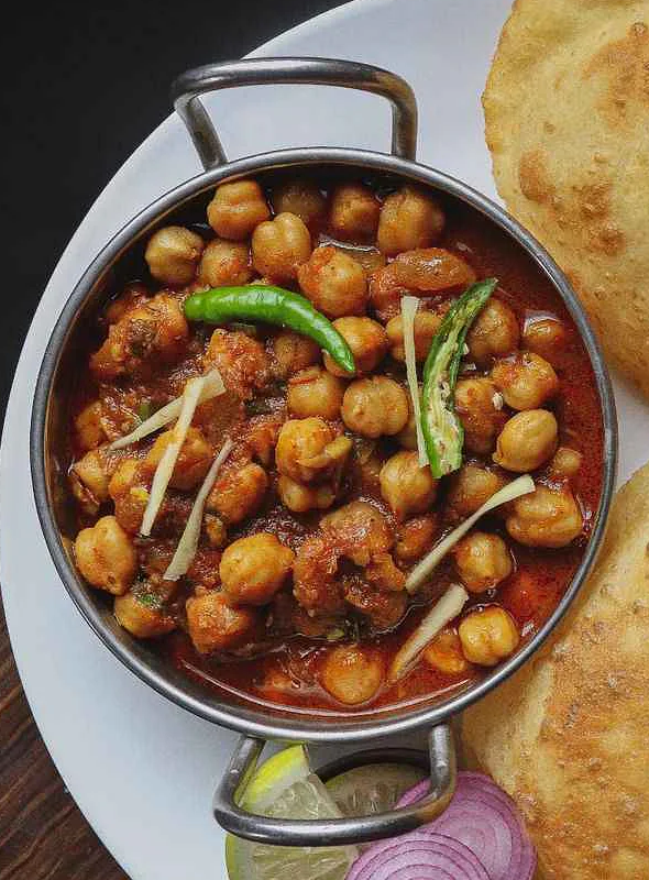 Chole masala, also known as chana masala or channay, is a popular Indian dish made with chickpeas, tomatoes, and a blend of spices. Pair with Poori/Rice/Roti/Paratha