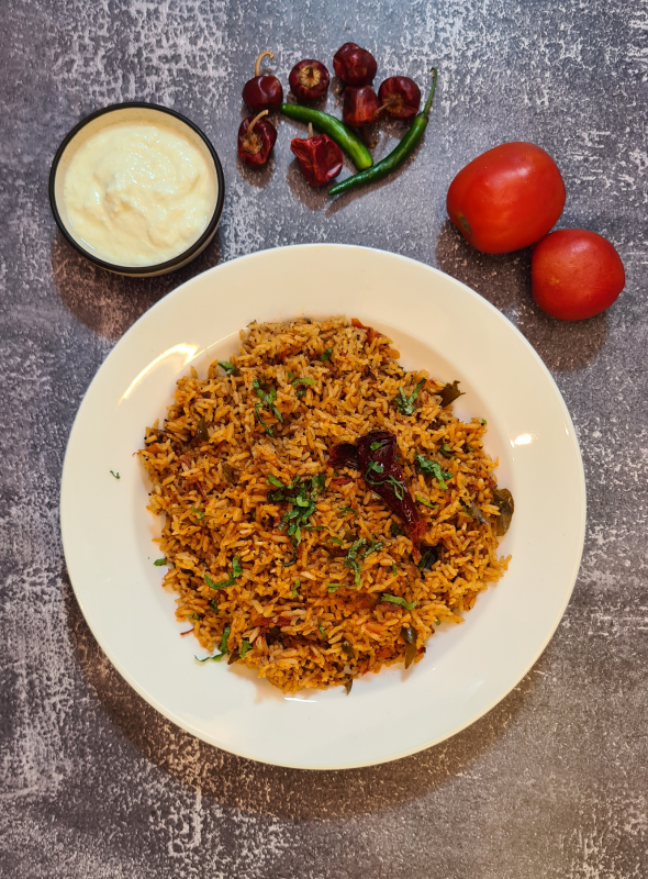A popular South Indian rice recipe, tomato rice can be made easily with leftover rice, tomatoes, and a bunch of spices. Pair with Raita/Curd