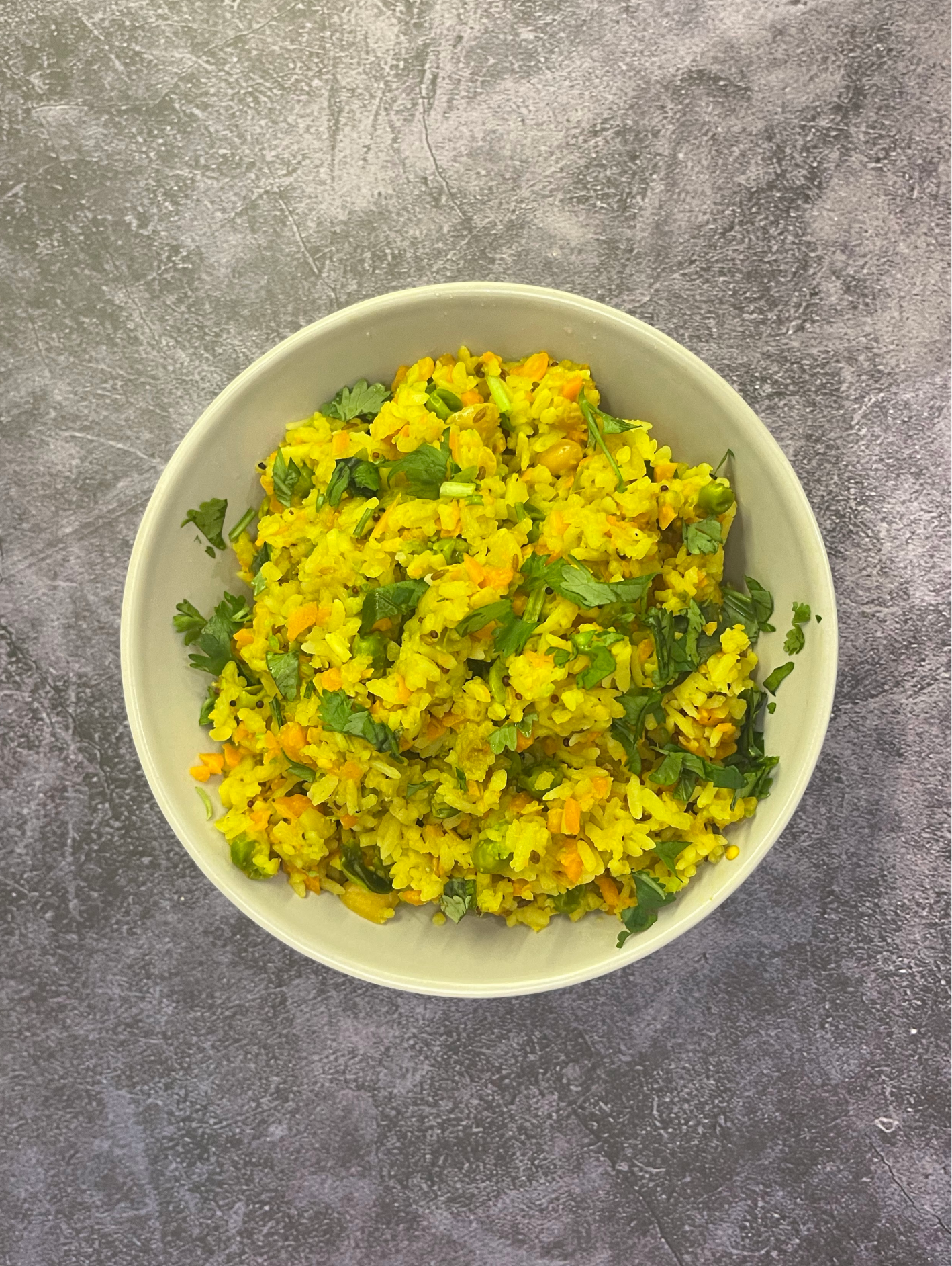 A popular Indian breakfast dish, made in Maharashtrian-style, using flattened rice, herbs, onions, and spices and absolutely no oil!!