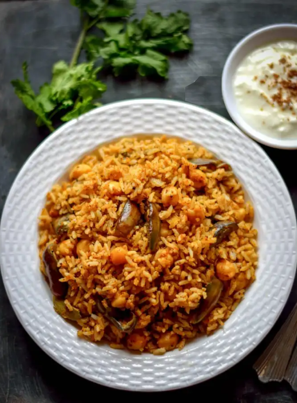 Vangi Bhath is a rice dish popularly made in the Maharashtrian and Karnataka cuisine. This is a simple one pot vegan recipe of spiced brinjal rice. Pair with Curd/Raita