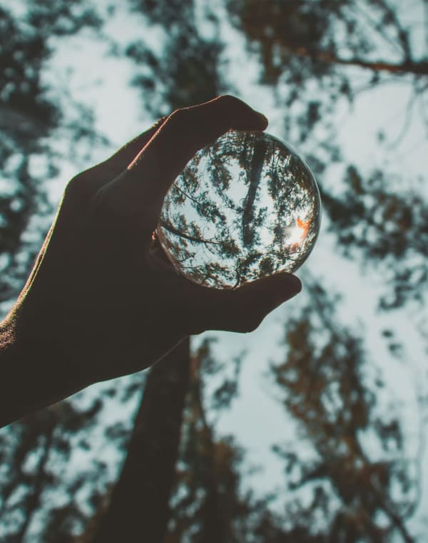 Une boule de verre tenue à bout de bras dans la lumière