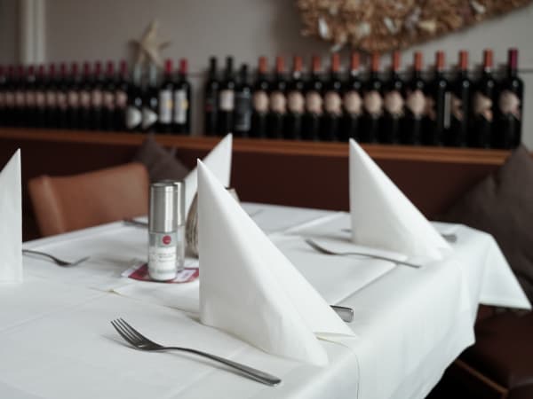 Festlich gedeckter Tisch mit Weinregal