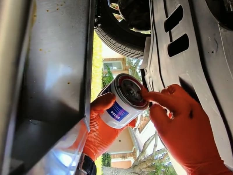 Fresh oil filter going in during a mobile oil change