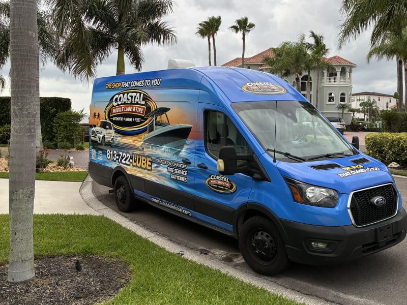 Coastal Mobile Lube van parked in a residential driveway under palm trees for an on-site service visit