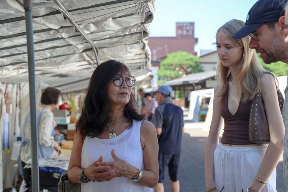 Local guide translating for guests at a food stall in Takayama