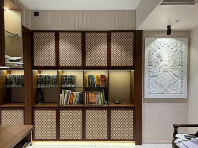 Sophisticated commercial office with warm wood tones, pendant lighting, open plan layout, and curated greenery in bright daylight
