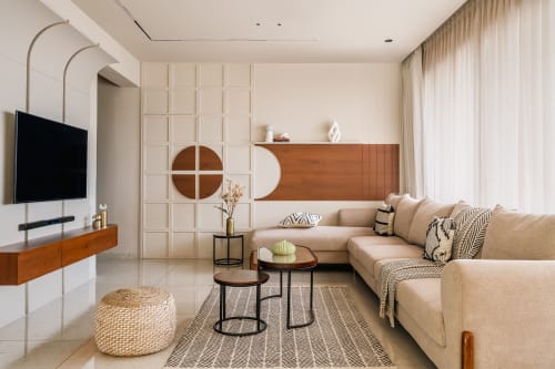 Warm residential living room with cream upholstered furniture, natural oak floors, and layered neutral textiles in soft afternoon light