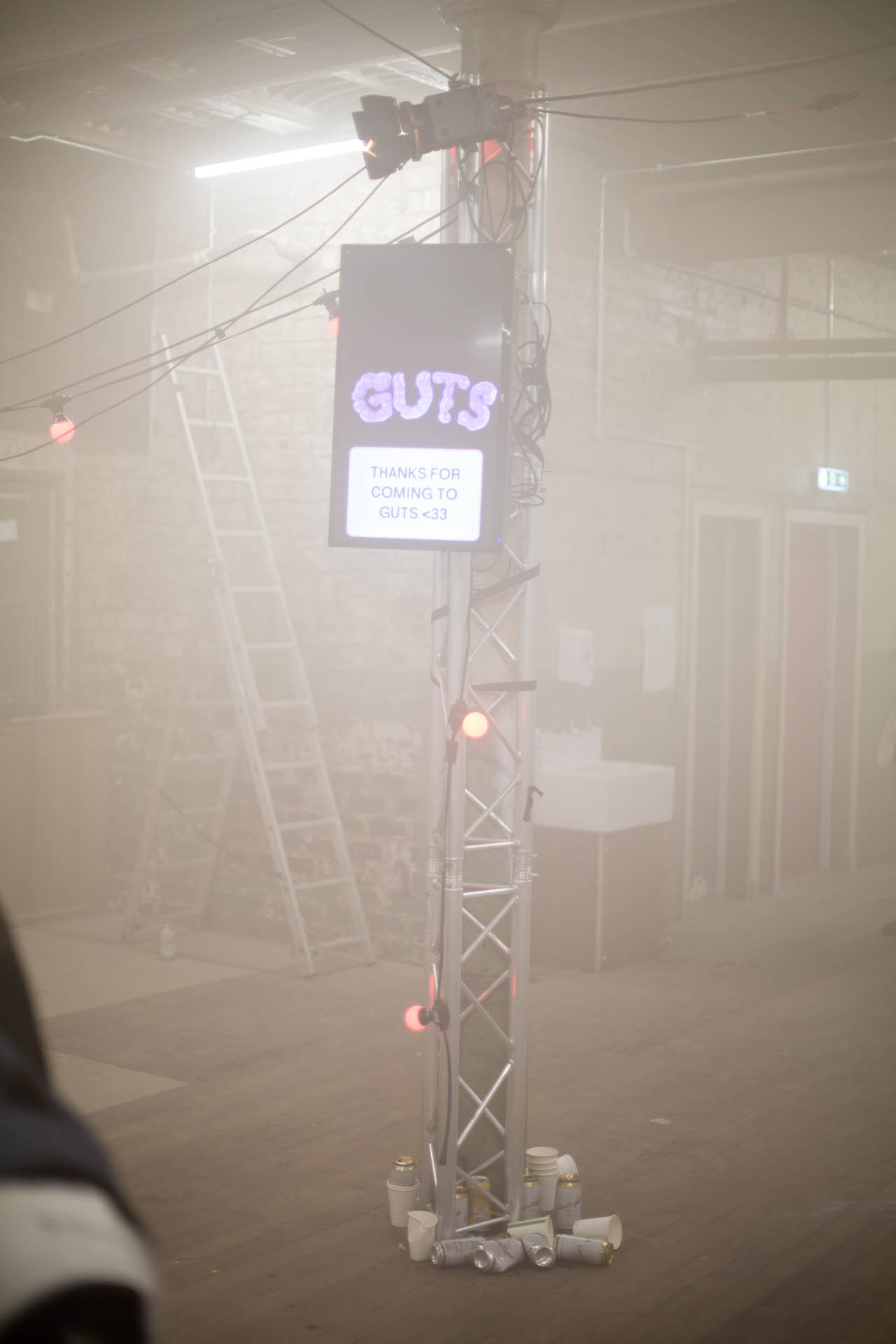 TV mounted to a tall truss displays the words "thanks for coming"