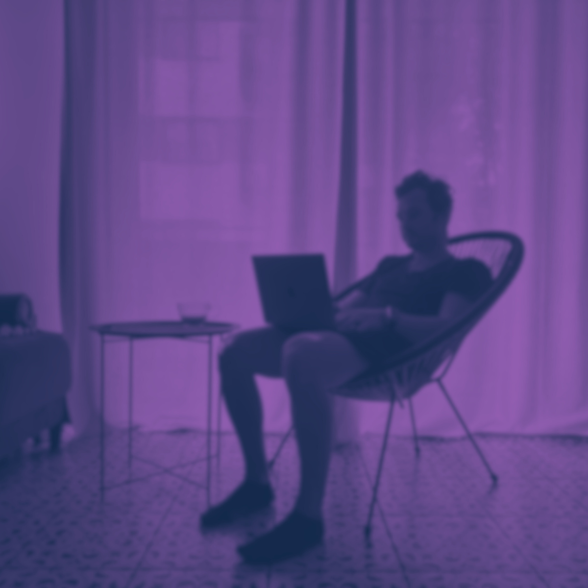 A guy sitting in a chair with a laptop