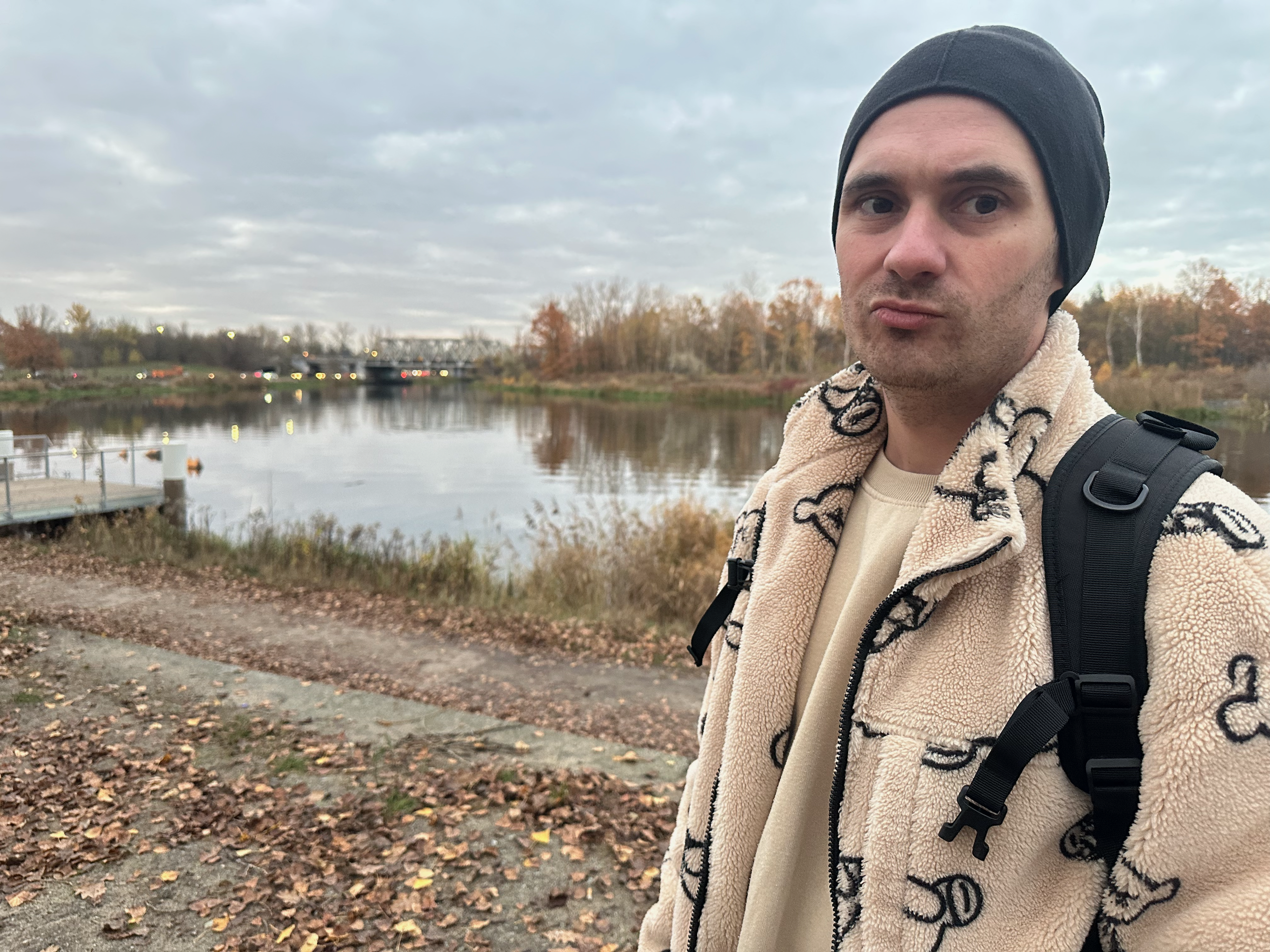 A man standing near the river bank with a grumpy face