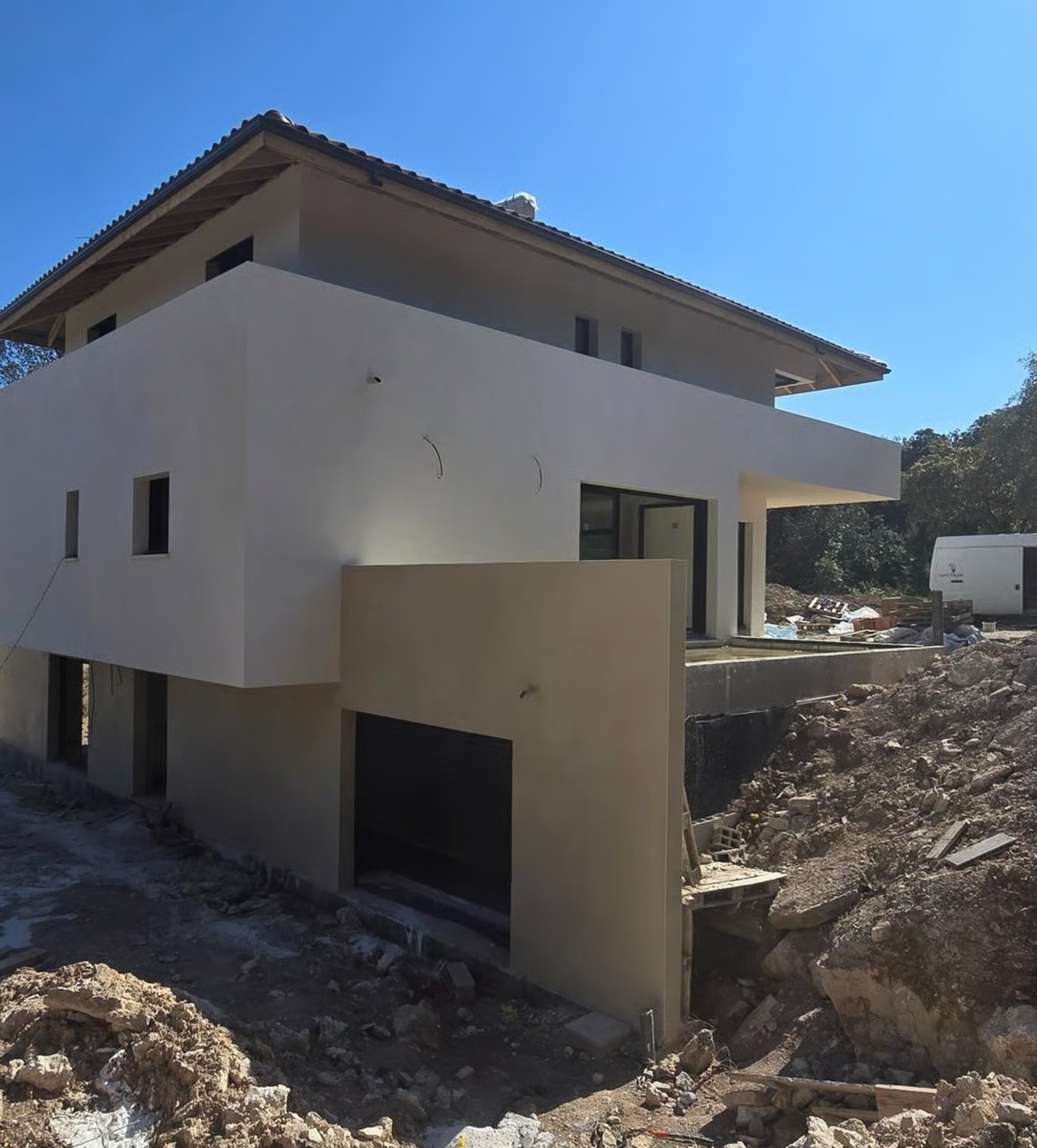 Maison contemporaine avec façade enduite en blanc sous un ciel bleu — bassin genevois