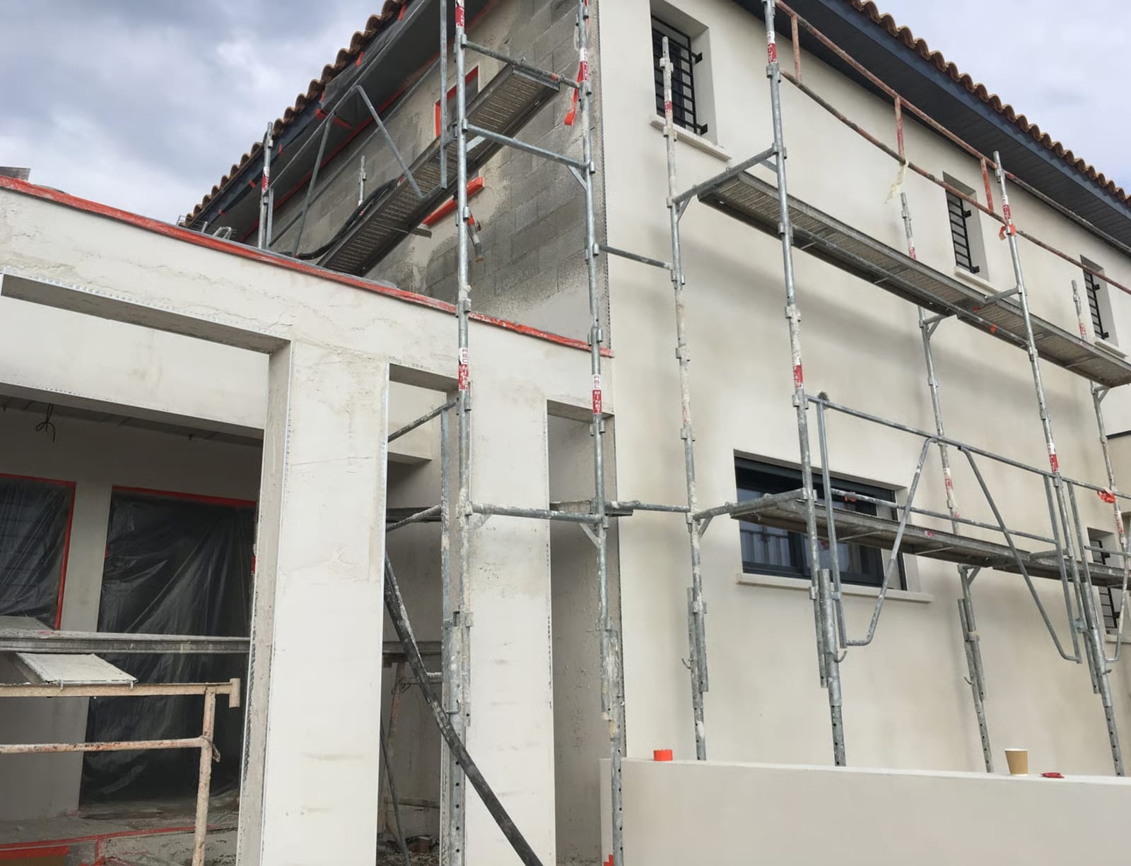 Chantier de ravalement de façade en cours avec échafaudage installé