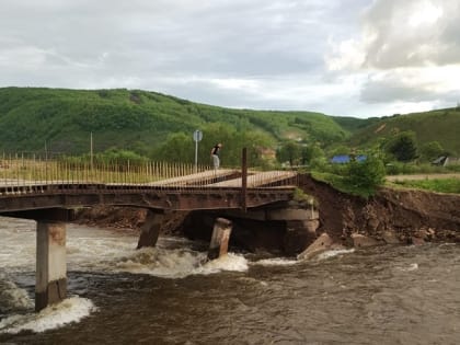 Потоки воды размыли опору моста в Облучье: часть города отрезана