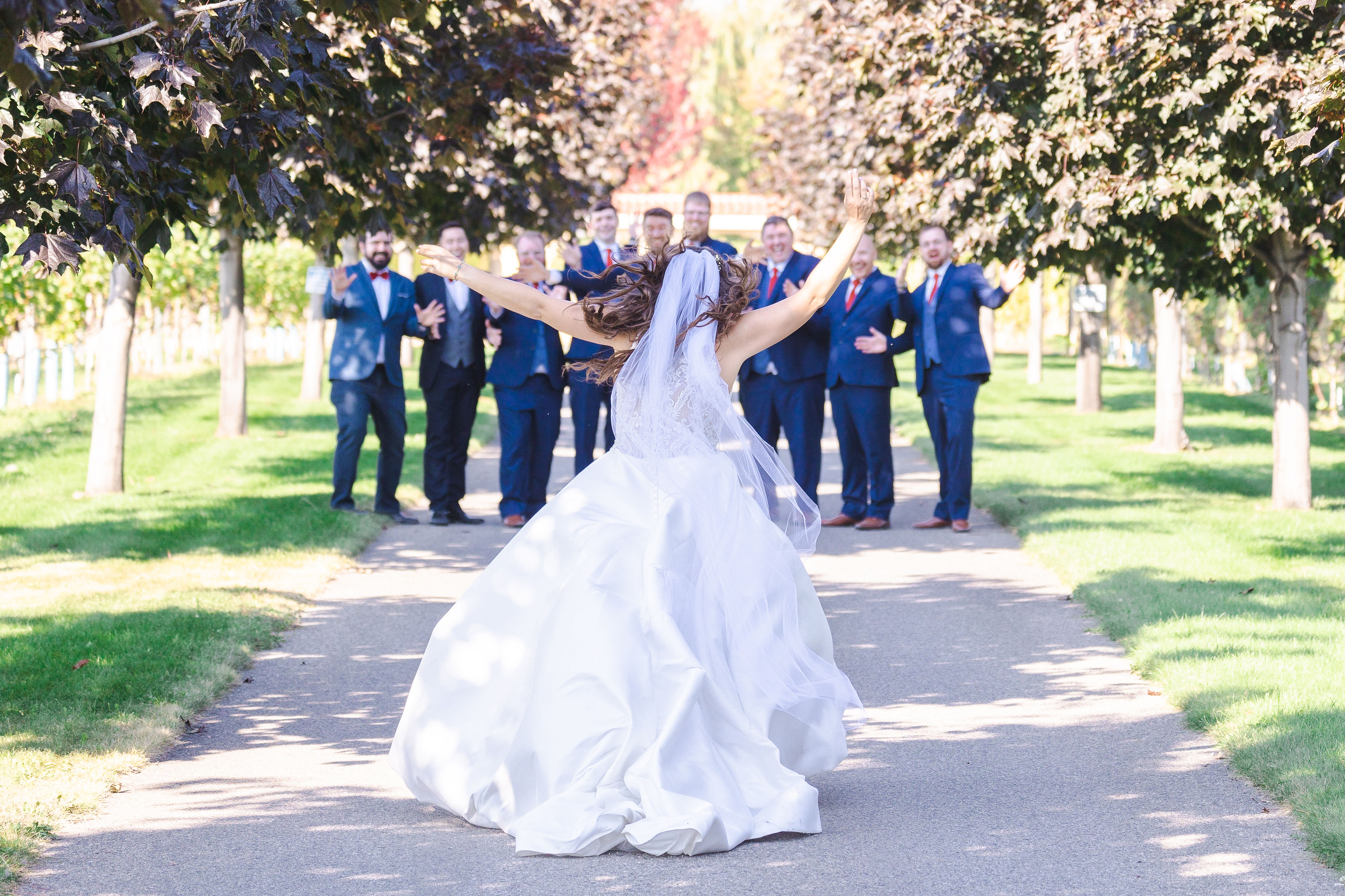 cinematic wide shot of a wedding couple embracing in an orchard during golden hour