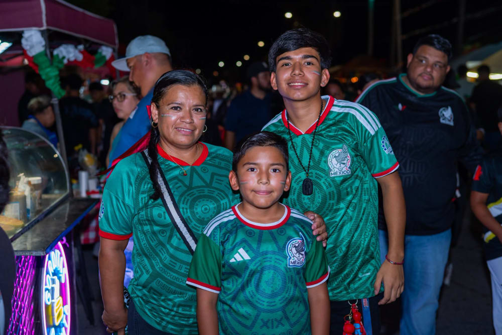 Familia con camisetas de la Selección Mexicana y banderitas pintadas en el rostro