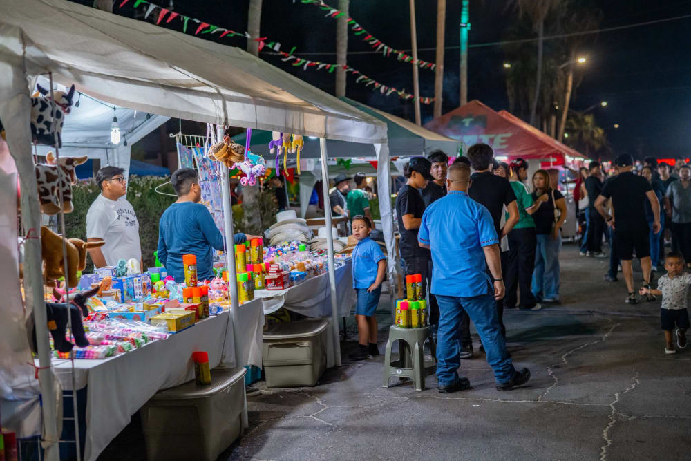 Personas recorriendo los puestos de juguetes y artículos de fiesta