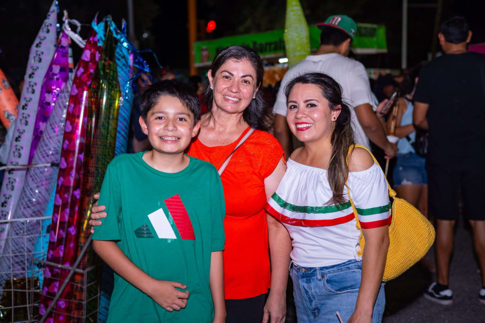 Niños y adultos con globos y blusa campesina tricolor en la verbena