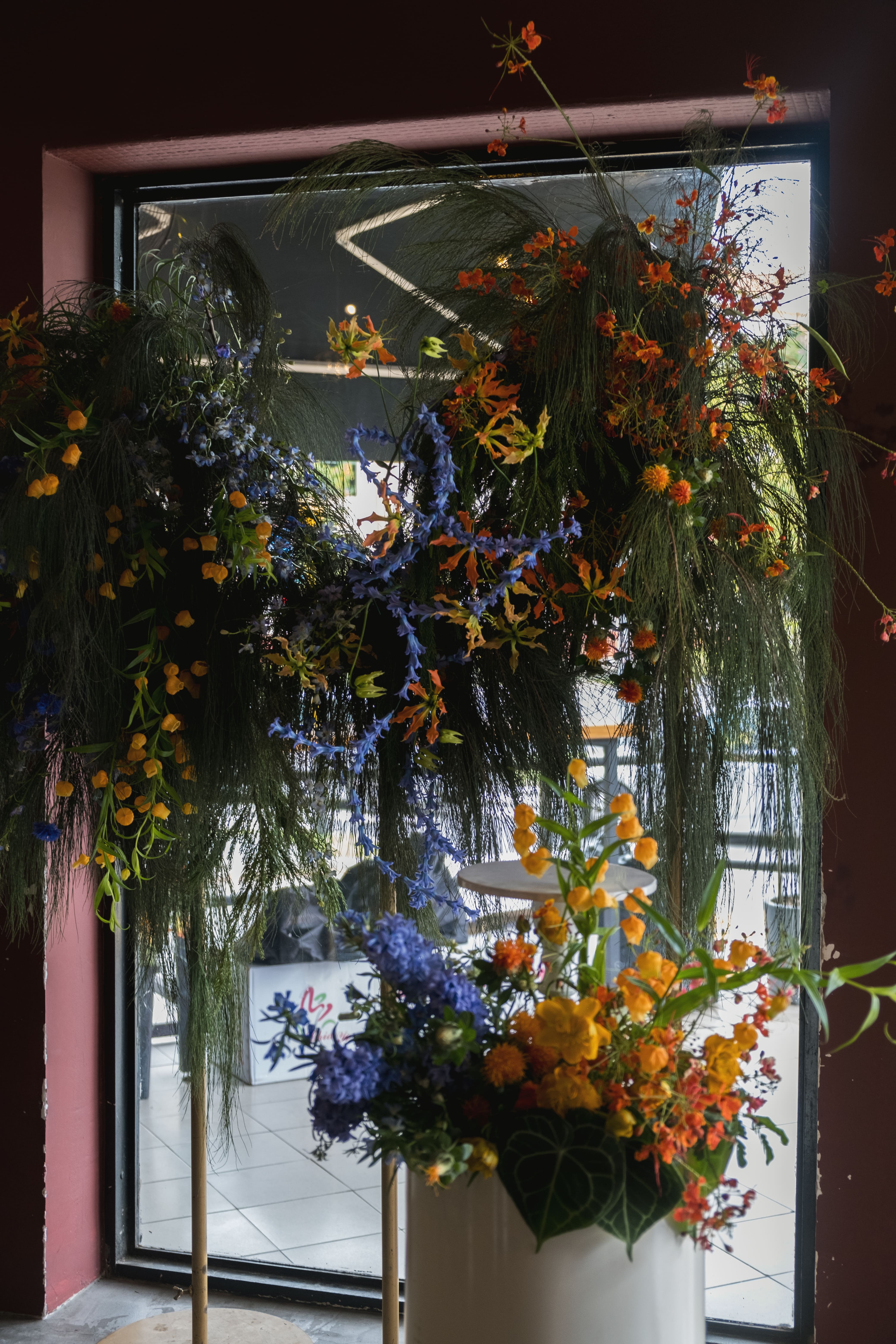 Backdrop and pedestal floral with orange and blue blooms.