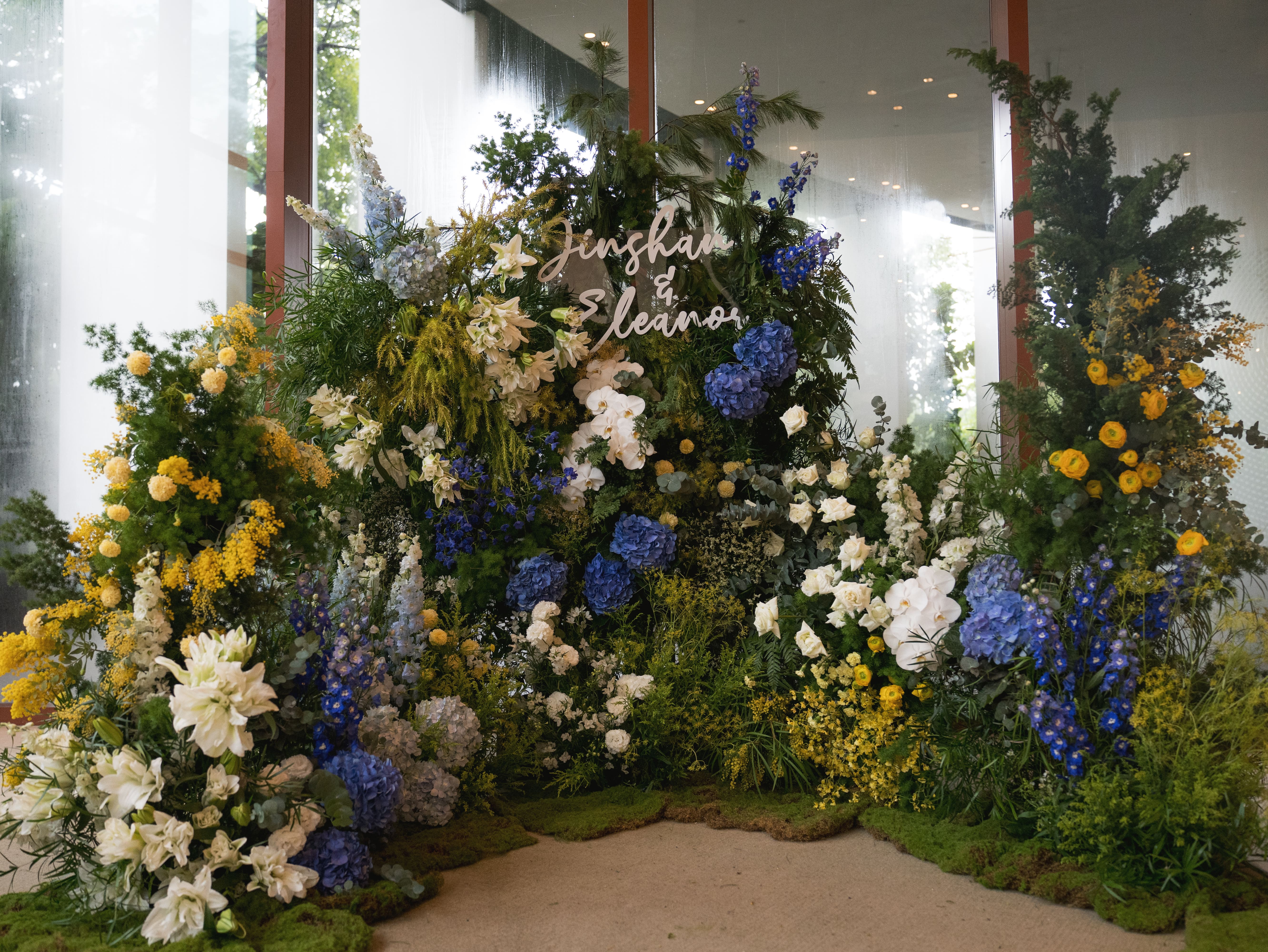 Main floral photo wall with moss base and fresh blooms