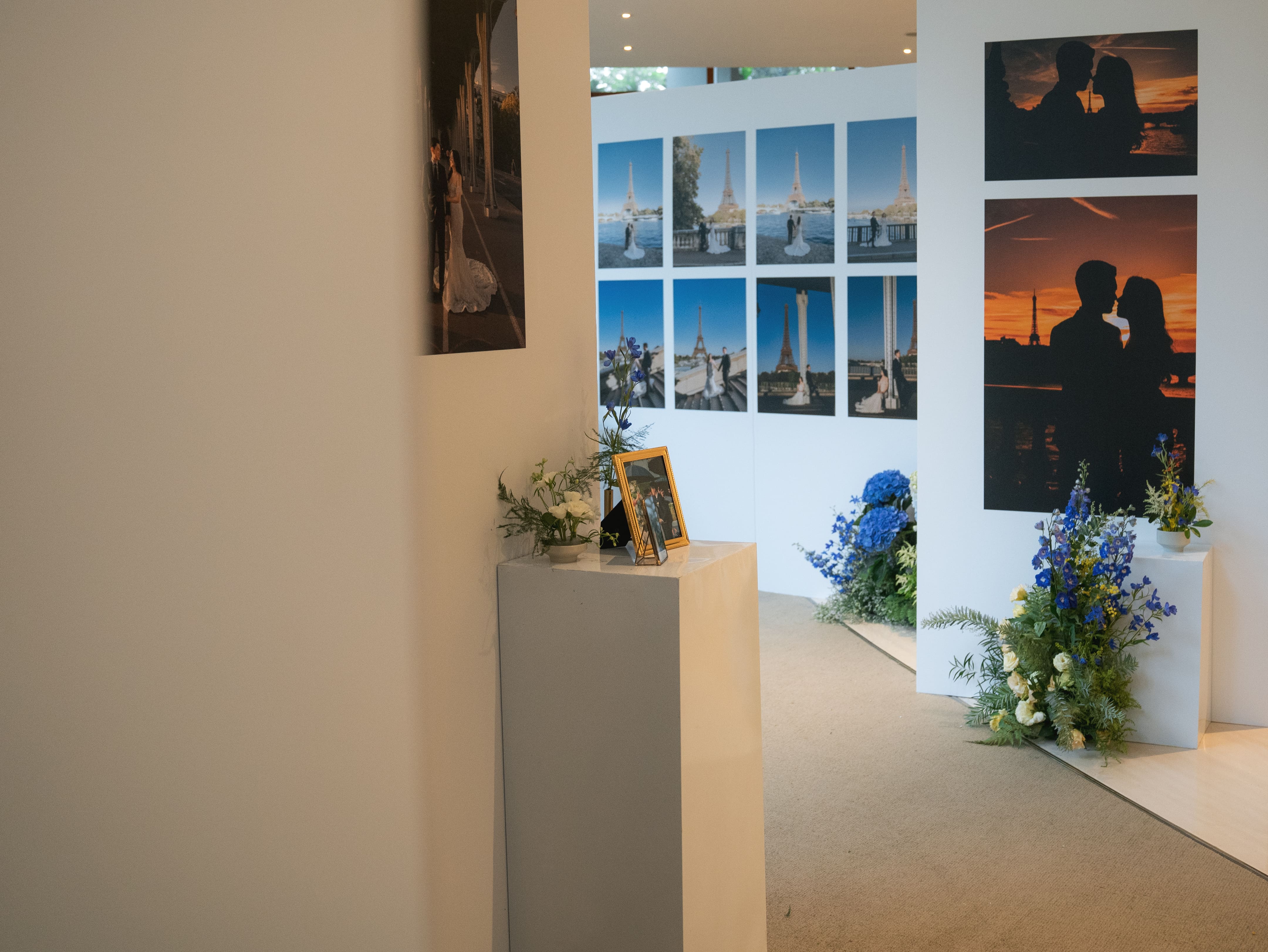 Minimalist floral arrangement on a white pedestal decorating the wedding photo gallery.