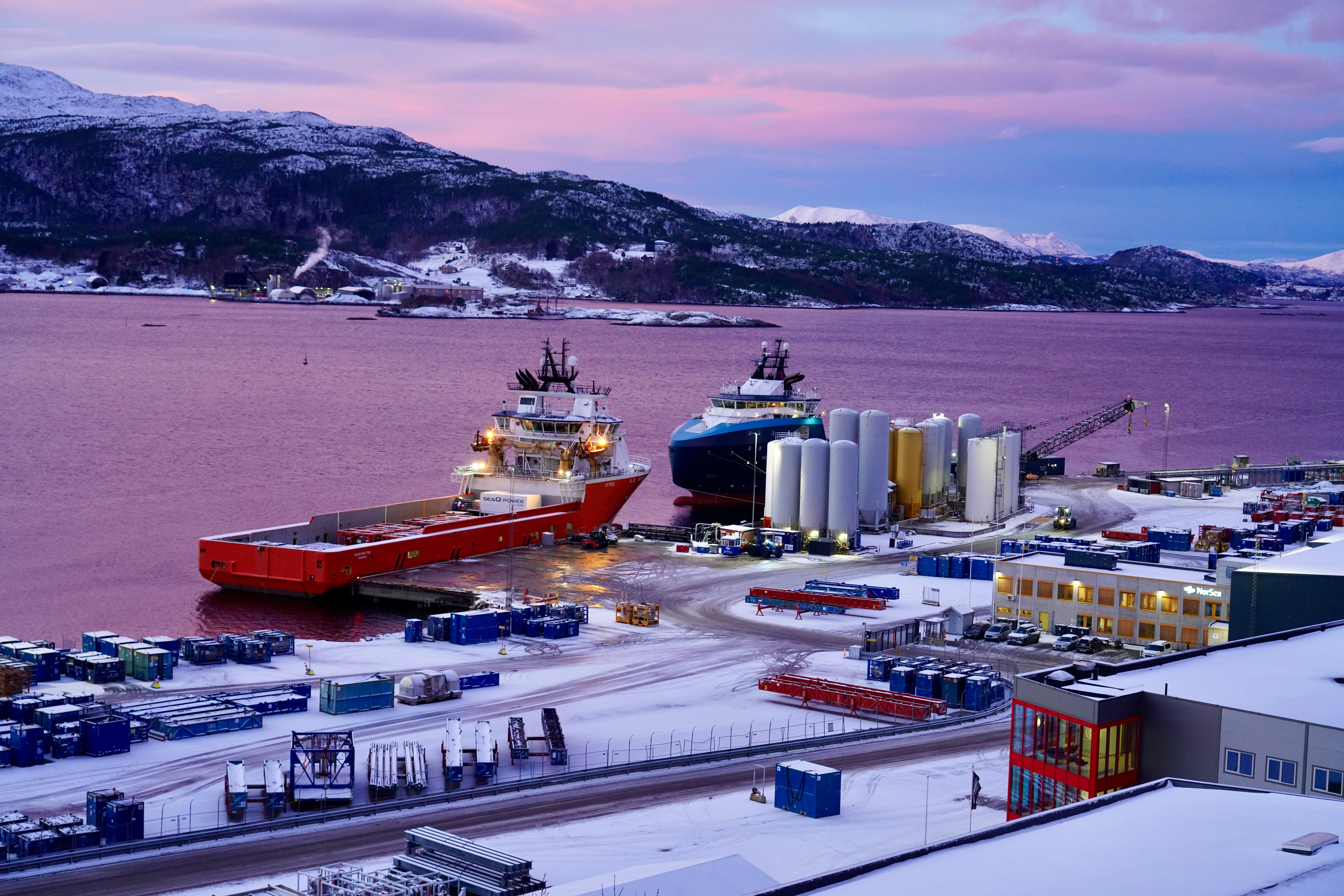 Snowy harbour at dusk with docked ships
