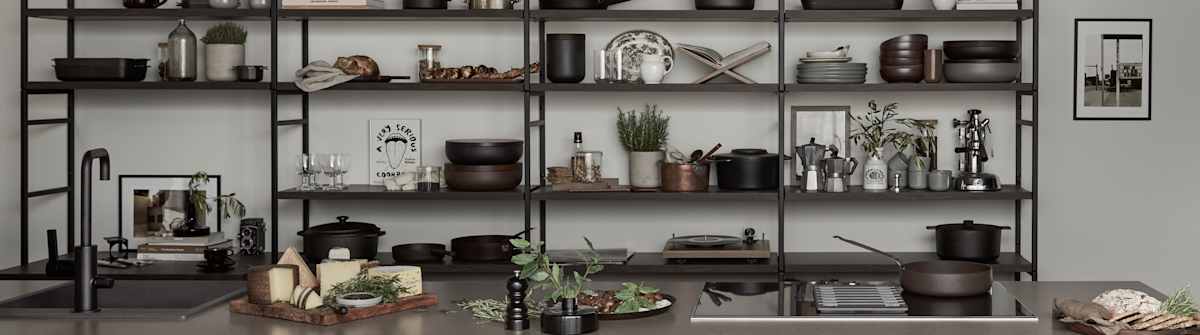 Marbodal Arkitekt plus Bark - kökslucka i målad brun kulör. Köksö med bänkskiva Iron Bark i kvartskomposit, diskho Franke Mythos. Stor vägghylla med ett integrerat skrivbord ger plats att sätta din stil på köket.
