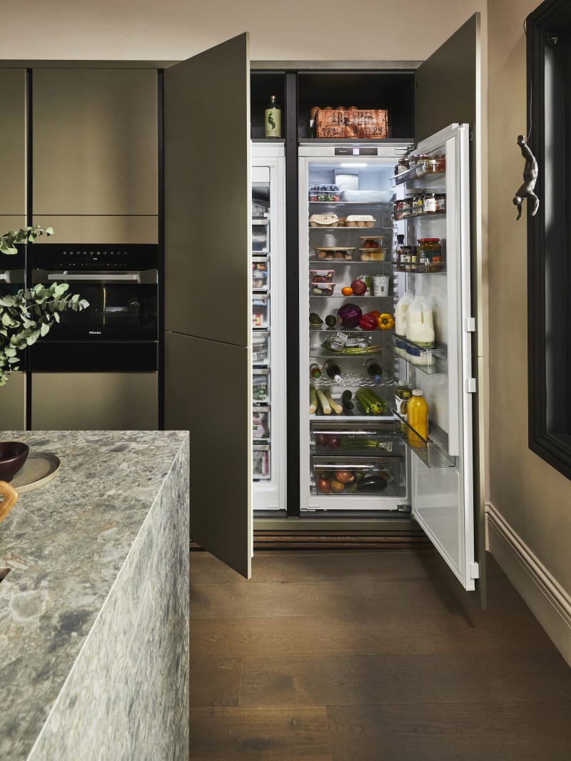 Wide open integrated double refridgerators in Soho Balmoral Cabinets, with a view of the corner of the Dekton worktop-covered kitchen island in the foreground.