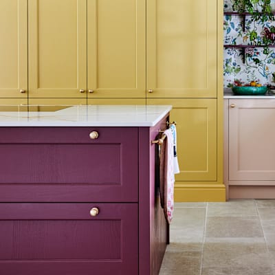 Wide image of sink, kitchen island and pantry larder. Ludlow cabinetry from Magnet in colours Burlington Red, Chalk blush and Harvest in Heritage classic with a contemporary twist.